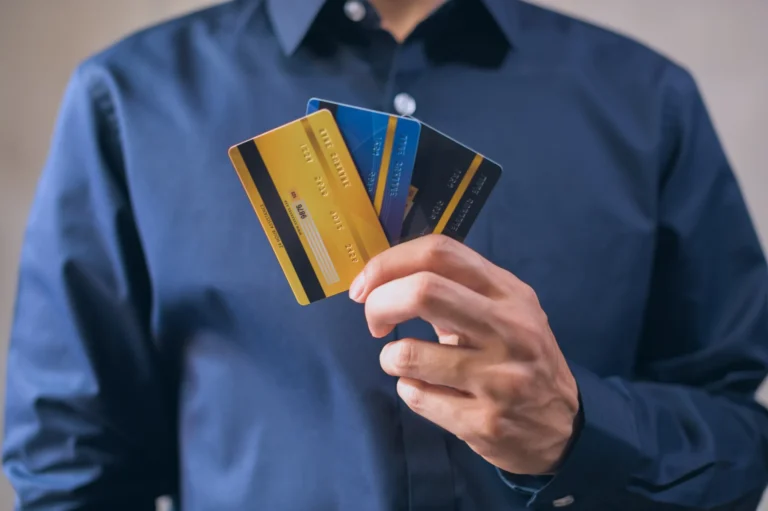 Person holding several credit cards, representing consumer credit and debt in 2026
