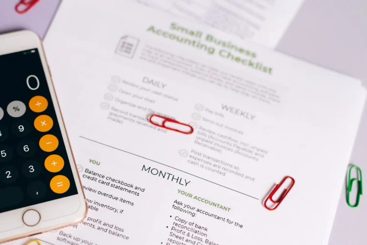 Calculator and financial documents used to review small business loan costs