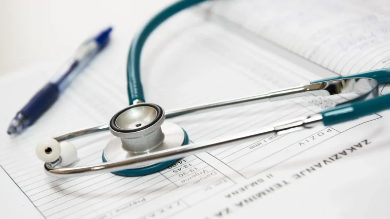 Stethoscope and pen resting on a medical report