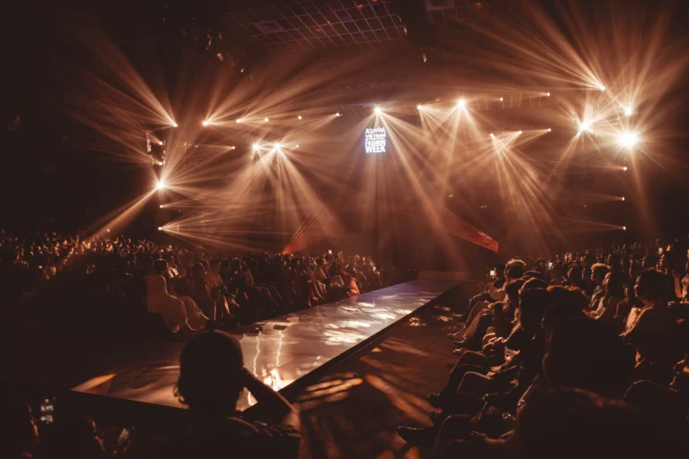 Runway show at a fashion week event with dramatic stage lighting