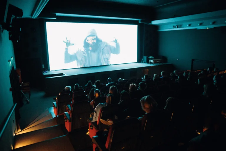 Crowded cinema theater with an audience watching a movie on the big screen