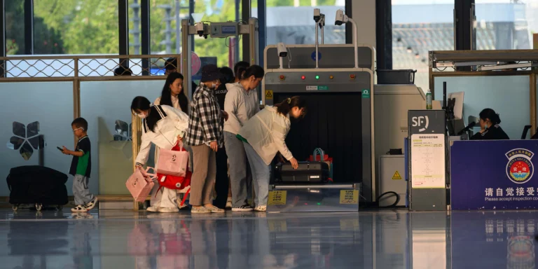 Travelers going through an airport security checkpoint under REAL ID rules