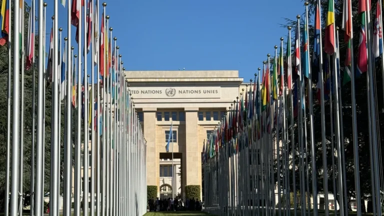 Member state flags lining the pathway to a United Nations building, representing the UN Secretary-General selection process