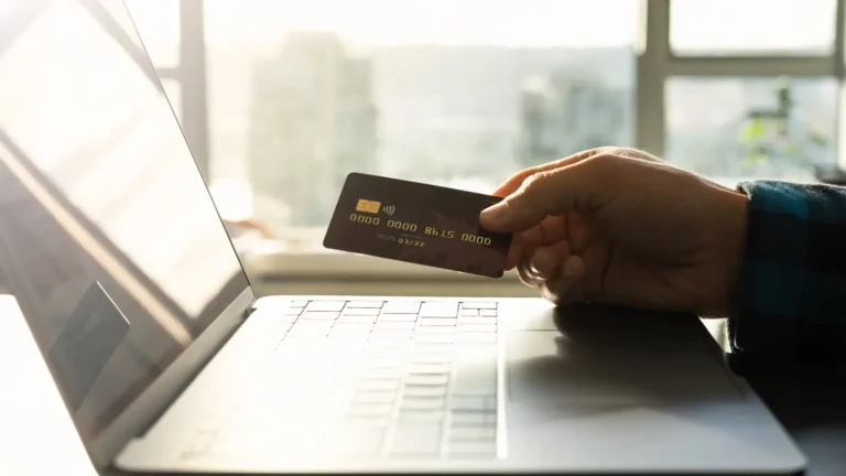 Person shopping online with a credit card and laptop