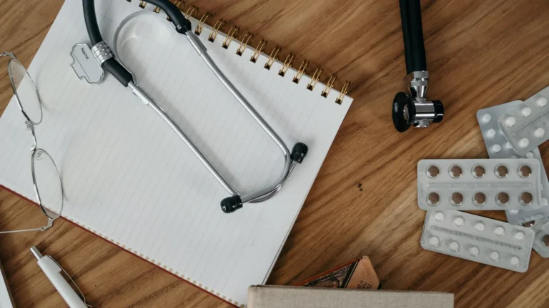 Stethoscope and notebook on a wooden desk