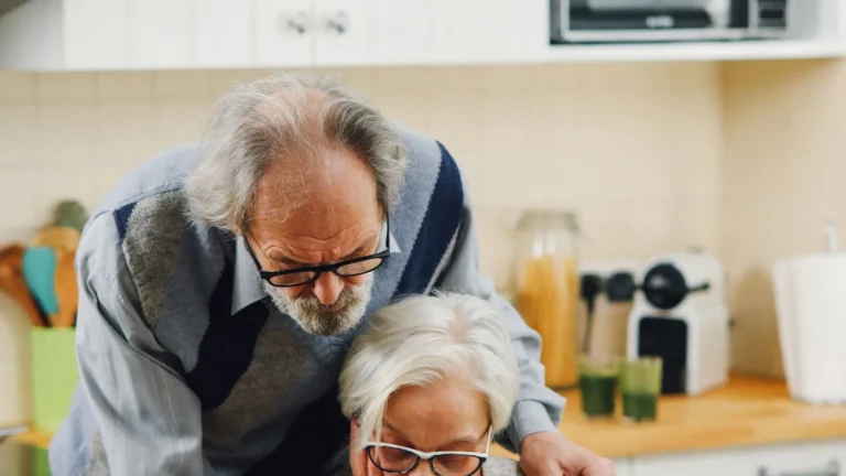 Older couple reading insurance documents together at a table