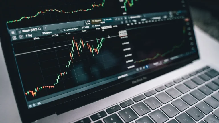 Laptop screen showing stock market charts for a tax-loss harvesting guide